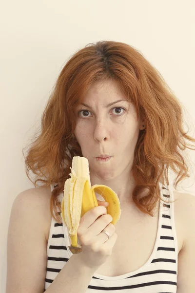 Młoda kobieta je banana. — Zdjęcie stockowe