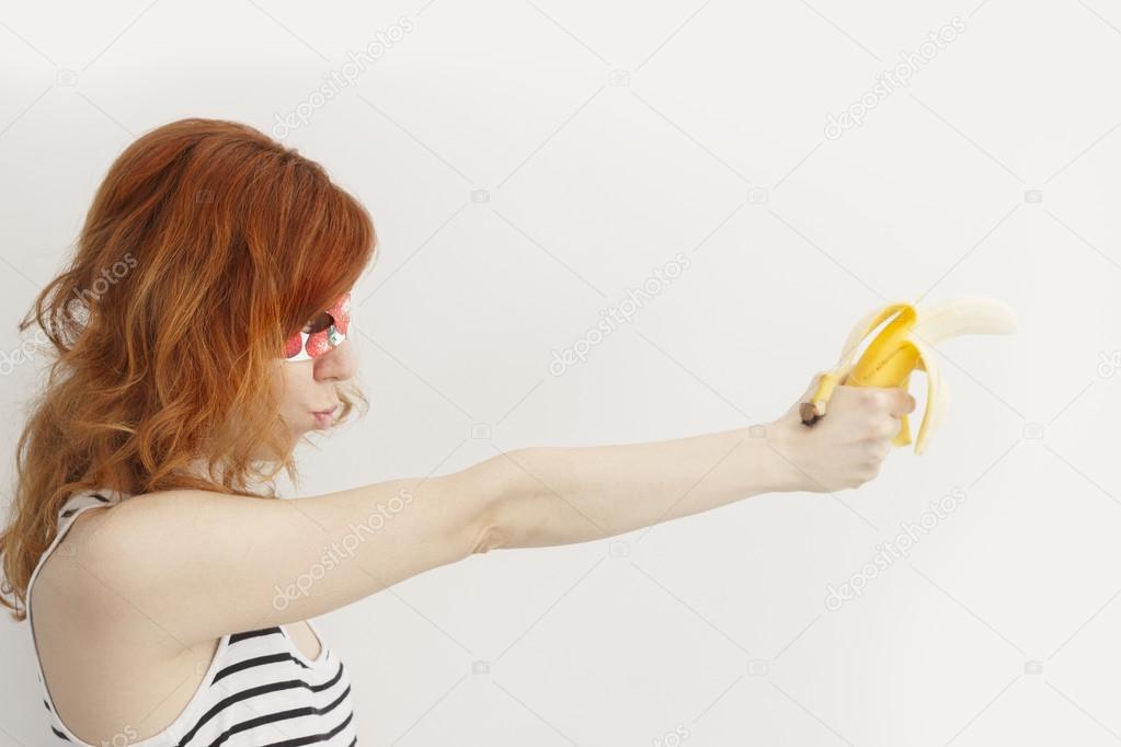 Superhero girl holding a banana gun