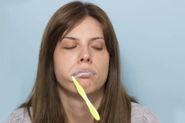 Mujer bella y soñolienta cepillándose los dientes por la mañana — Foto de Stock