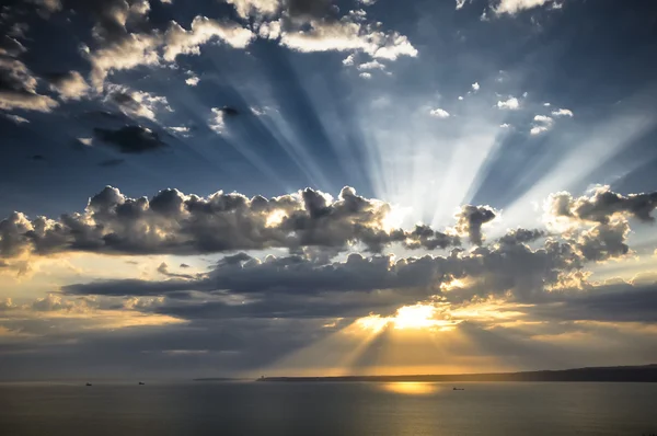 Солнечные лучи на закате с облаками — стоковое фото