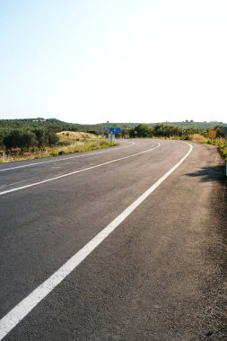 Gün ışığında kırsal yol geçmişini bükmek.