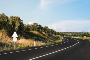 Gün ışığında kırsal yol geçmişini bükmek.