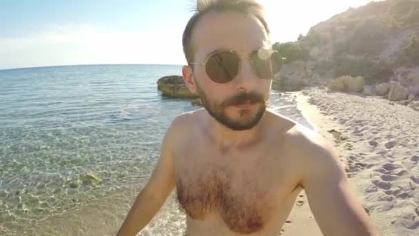 30年代的男性 戴着太阳镜在海滩上散步 拍摄自拍的镜头 — 图库视频影像