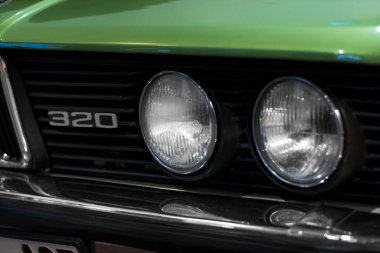 İzmir, Türkiye - 21 Haziran 2021: 1975 ile 1983 yılları arasında Almanya 'da üretilen bir BMW 320 marka yeşil araba farının yakın çekimi. İzmir 'de Editör Fotoğrafı.