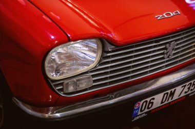 İzmir, Türkiye - 21 Haziran 2021: 1965-1976 yılları arasında Fransa 'da üretilen bir Peugeot 204 kırmızı araba farının yakın çekimi. İzmir 'de Editör Fotoğrafı.