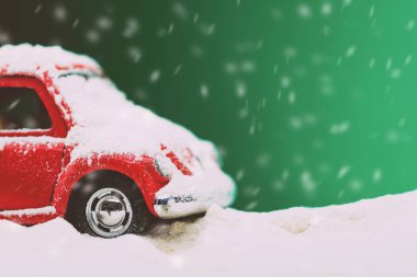 Mat yeşil arka planda oyuncak model bir arabanın yakın plan görüntüsü ve karla kaplı..