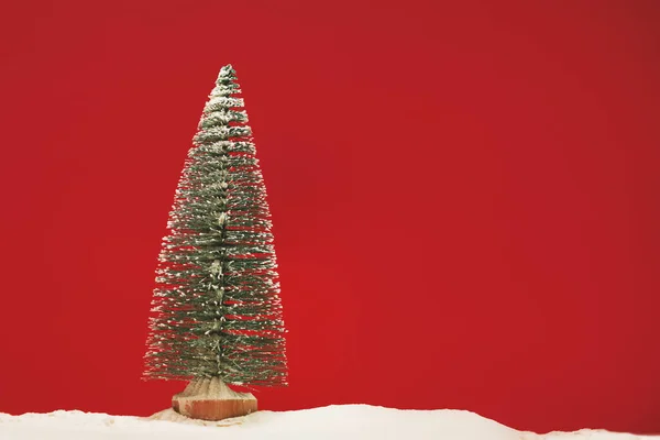 Pino Sobre Fondo Rojo Mate Con Poco Nieve — Foto de Stock