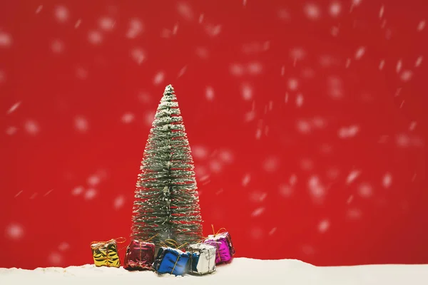 Biraz Kar Hediye Kutusuyla Kırmızı Arka Planda Bir Çam Ağacının — Stok fotoğraf