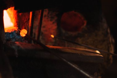 Close up shot of pruducing evil eye or amulet near the furnace. The amulet is red because its scorching.