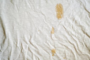 White fabric with coffee stain and wrinkles.
