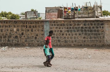 Cibuti, Cibuti - 21 Mayıs 2021: Cibuti 'de bir duvarın önünde yürüyen iki Cibuti' li kardeş. Cibuti 'de editör fotoğrafı.