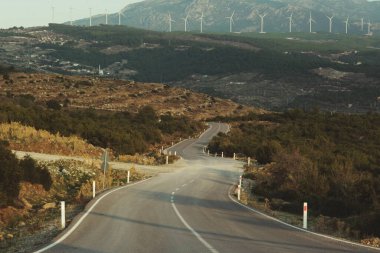 Tepelerde yel değirmenleri olan köy yolunu bükmek.. 