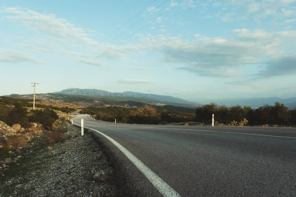 Tepelerde yel değirmenleri olan köy yolunu bükmek.. 