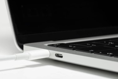 USB C kablosunun bir dizüstü bilgisayara bağlanmış görüntüsünü kapat.