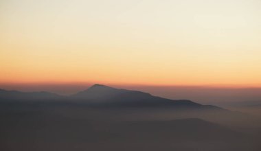 Alacakaranlıkta sisli dağ zirvesi