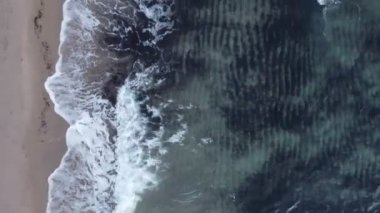 Kum plajının köpüklü dalgalı havadan görüntüsü