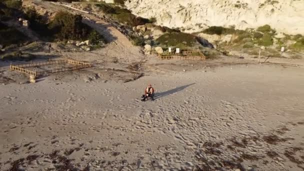 Съемка Воздуха Пляжа Клеопатры Одиноким Человеком Сидящим Пляже Шляпе Пальто — стоковое видео