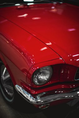 İzmir, Türkiye - 4 Aralık 2021: Fuar İzmir 'de bir otomobil fuarında kırmızı renkli klasik bir Ford Mustang arabasının ön görüntüsü.