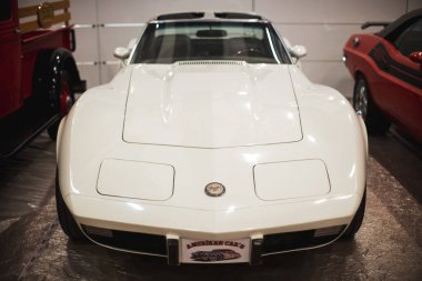 İzmir, Türkiye - 4 Aralık 2021: Fair İzmir Türkiye 'de bir otomobil fuarında beyaz renkli klasik bir Chevrolet Corvette aracının ön görüntüsü.