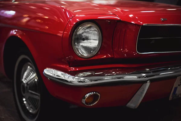 İzmir, Türkiye - 4 Aralık 2021: Fuar İzmir 'de bir otomobil fuarında kırmızı renkli klasik bir Ford Mustang arabasının ön görüntüsü.