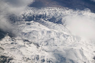 Bulutlu karlı dağların havadan görünüşü