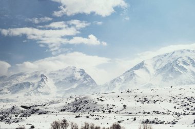 Karlı ve bulutlu dağların manzarası.