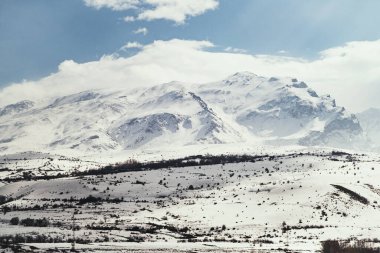 Karlı ve bulutlu dağların manzarası.