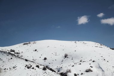 Karlı ve bulutlu dağların manzarası.
