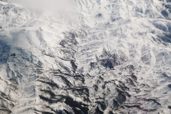 Bulutlu karlı dağların havadan görünüşü
