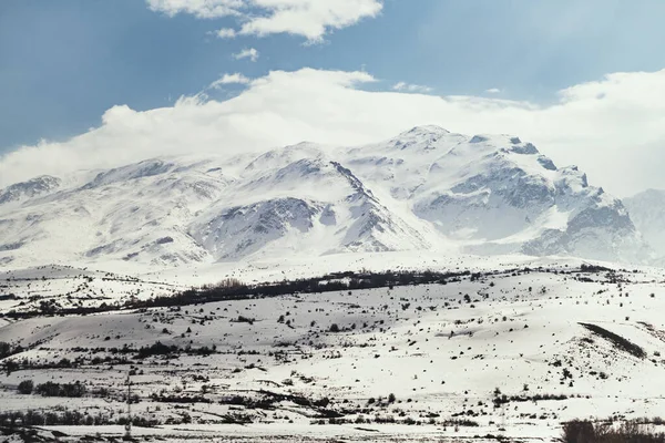 Karlı ve bulutlu dağların manzarası.