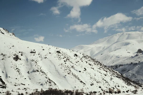 Karlı ve bulutlu dağların manzarası.