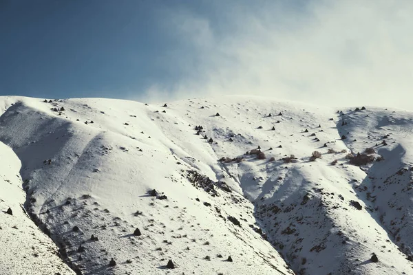 Karlı ve bulutlu dağların manzarası.