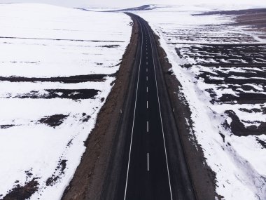 Kışın tek şeritli ve karlı bir yol manzarası.