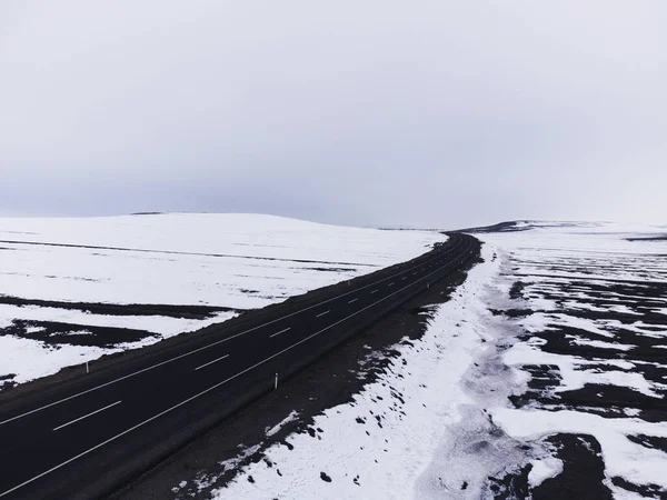 Kışın tek şeritli ve karlı bir yolun hava çapraz görüntüsü..