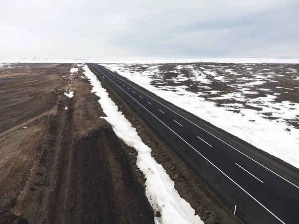 Kışın Tek Şeritli Karlı Bir Yolun Hava Çapraz Görüntüsü — Stok fotoğraf