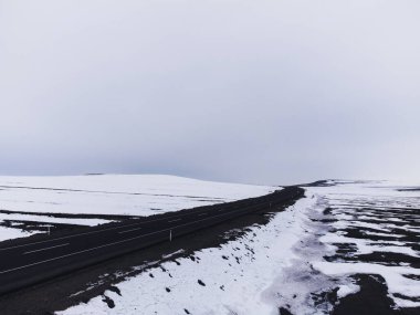 Kışın tek şeritli ve karlı bir yolun hava çapraz görüntüsü..