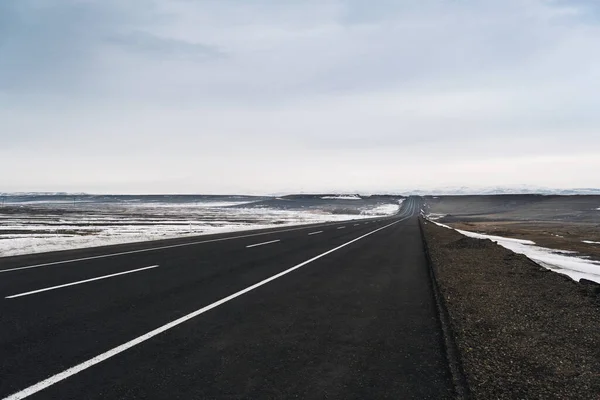 Вид Заснеженную Асфальтовую Дорогу Полосами Движения Зимним Бездорожьем — стоковое фото