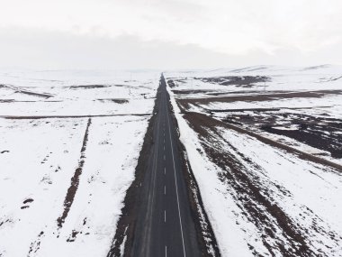 Kışın tek şeritli ve karlı bir yol manzarası.