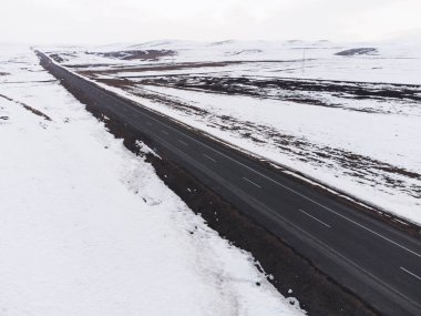 Kışın tek şeritli ve karlı bir yolun hava çapraz görüntüsü..