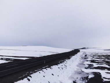 Kışın tek şeritli ve karlı bir yolun hava çapraz görüntüsü..