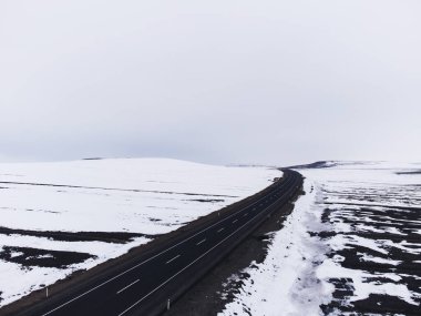Kışın tek şeritli ve karlı bir yolun hava çapraz görüntüsü..