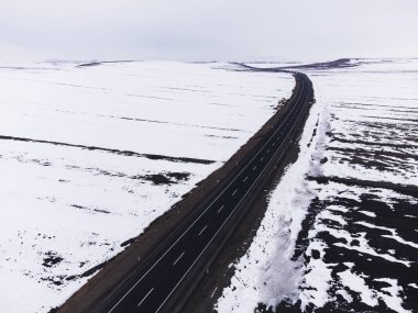 Kışın tek şeritli ve karlı bir yolun hava çapraz görüntüsü..