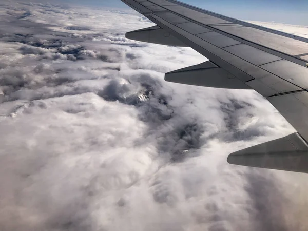 飛行機の窓からの雲と雪の山の空中風景 — ストック写真