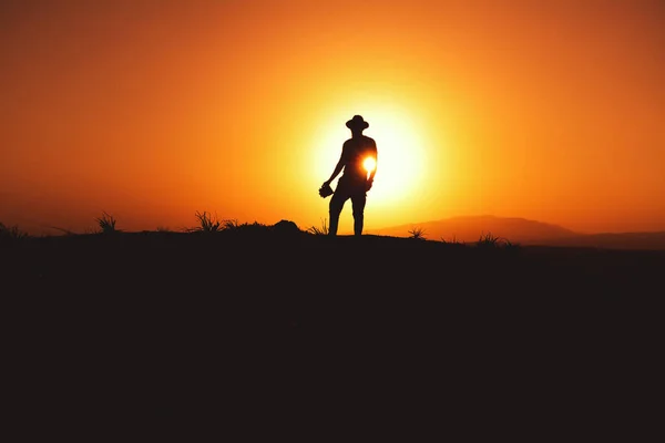 Silhouette Eines Mannes Mit Fedora Hut Bei Sonnenuntergang Auf Einem — Stockfoto