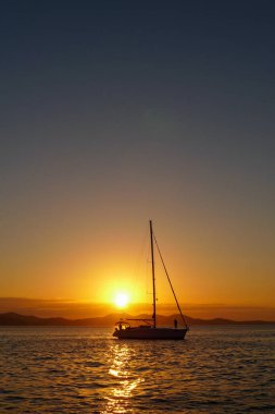 Adriyatik 'te gün batımında bir yelkenlinin silueti
