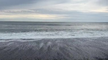Waves from the Pacific gently roll in at dusk on the rugged Rialto Beach in Olympic National Park. La Push, Washington.