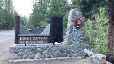 Kings Canyon Ulusal Parkı 'nın Grant Grove Village girişindeki taş ve ahşap giriş tabelası, ABD