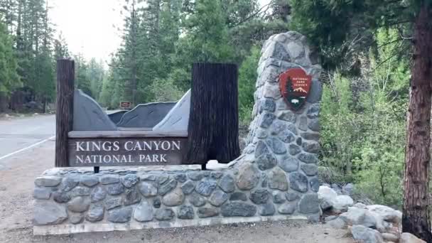 キングスキャニオン国立公園へのグラントグローブ村の入り口の石と木の入り口の標識 カリフォルニア州 アメリカ — ストック動画