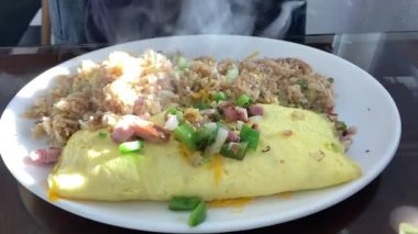 Taze omlet ve yeşil soğanlı kızarmış pilav, sağlıklı bir kahvaltı için beyaz tabakta servis edilir..