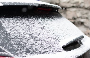 Kış zamanı arabanın arka camında beyaz kar var. Resmin merkezine odaklan